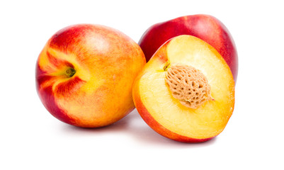 Close up of three nectarines and one is cut, isolated