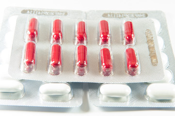 Red capsule in blister pack on white tablet