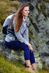 Naklejka na ściany i meble Woman hiker resting on a rock