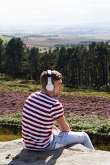 Fototapeta na wymiar Young Man Listening To Music In Countryside On Headphones