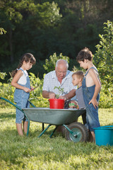 children is helping her Grandfather in the garden