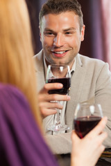 Happy man having glass of wine with his gorgeous girlfriend