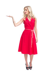 Fototapeta premium Smiling woman in red dress presenting something in her hand