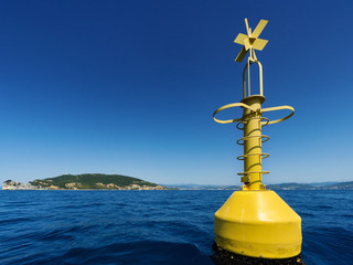 Yellow navigational buoy marker in sea