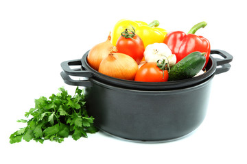 Healthy food. Fresh vegetables in black saucepan on a white back