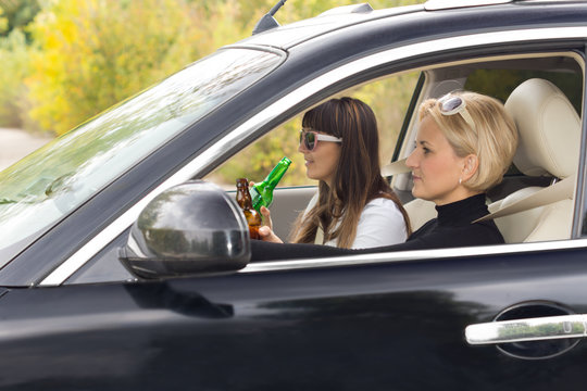 Two woman enjoying alcohol while driving