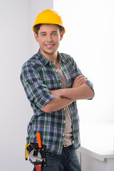 Handyman. Cheerful craftsperson looking at camera and keeping ar