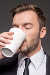 Man drinking coffee. Portrait of confident young men drinking