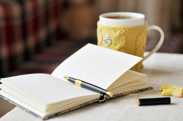 Hot tea in a mug, wrapped in a knitted cup-holder