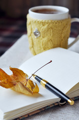 Hot tea in a mug, wrapped in a knitted cup-holder
