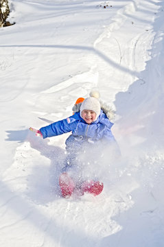 Little girl on a sled in the winter