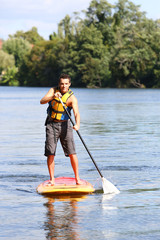 Mn riding stand-up-paddle in river