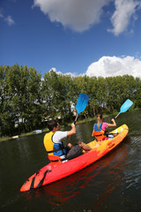 Couple riding canoe in river