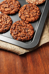 Homemade cookies on dripping pan, on wooden background
