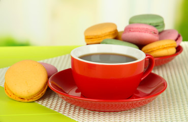 Coffee and macaroons on table on light background