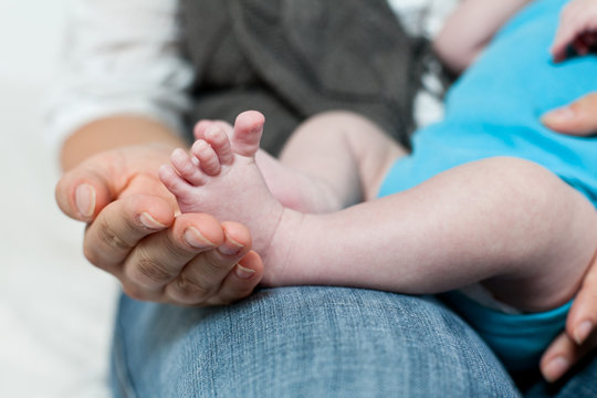 Babies Füße in Mamas Hand