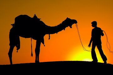 Silhouette man and camel at sunset. Jaisalmer, India