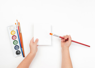 Child draws watercolors on blank sheet