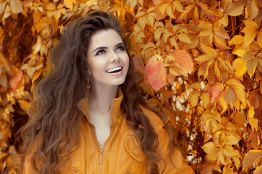 Enjoyment. Young happy smiling brunette woman over autumn leaves