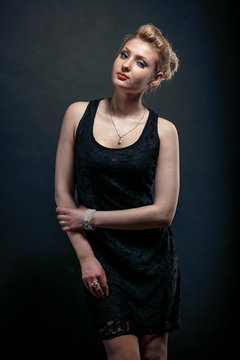 Studio portrait of blonde girl posing in black dress