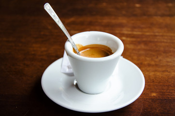 White espresso cup standing on the wooden table