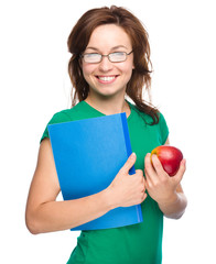 Young student girl is holding book and apple