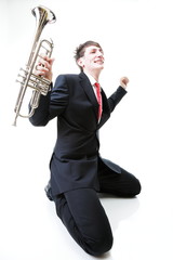 Excited man kneeling with trumpet in hand and screaming. Isolate