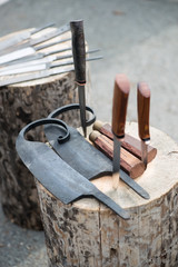 Fototapeta na wymiar Knife preforms on a wooden log, vertical shot