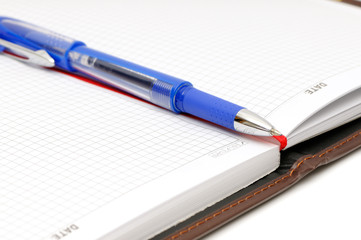 Notebook and ball-point pen on white background