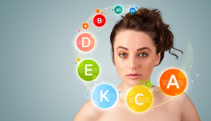 Pretty young girl with colorful vitamin icons and symbols