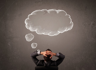 Businessman sitting with cloud thought above his head