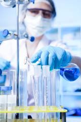 Scientific researcher holding at a liquid solution in a lab