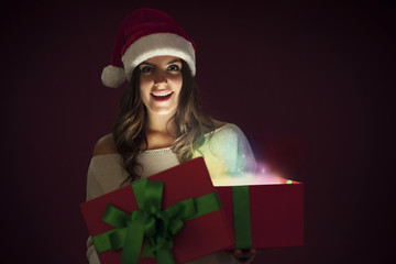 Woman with santa hat opening magic gift