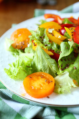 salad with red and yellow peppers and lettuce and tomatoes
