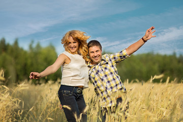 Fototapeta na wymiar Couple jumping in rye field