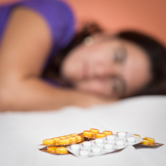 Depressed or suicidal person looking at a heap of pills
