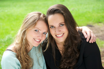 Portrait of two female friends smiling together outdoors