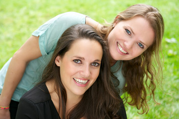 Portrait of two young women laughing outdoors