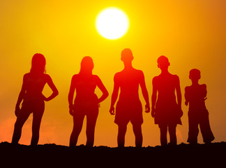 Silhouettes of boys and girls on the beach