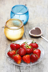 Fresh strawberries and cake pop in heart shape on wooden table.