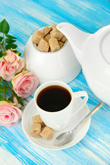 Cup of coffee, teapot and sugar-bowl on color wooden background