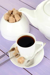 Cup of coffee, teapot and sugar-bowl on color wooden background