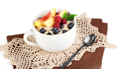 Oatmeal in cup with berries on napkins isolated on white