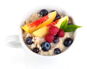 Oatmeal in cup with berries isolated on white