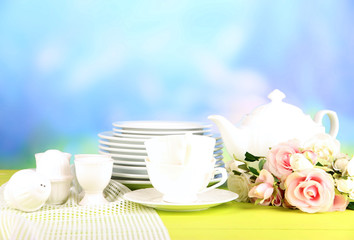 Lots beautiful dishes on wooden table on natural background