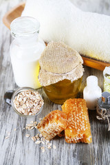 Honey and milk spa with oils and honey on wooden table close-up