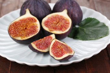 Ripe figs on plate wooden table close-up