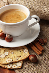 Cup of tasty coffee with Italian biscuit, on wooden background