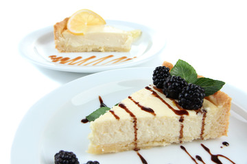 Slices of cheesecakes on plates, isolated on white