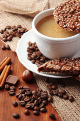 Cup of tasty coffee with tasty cookies, on wooden background